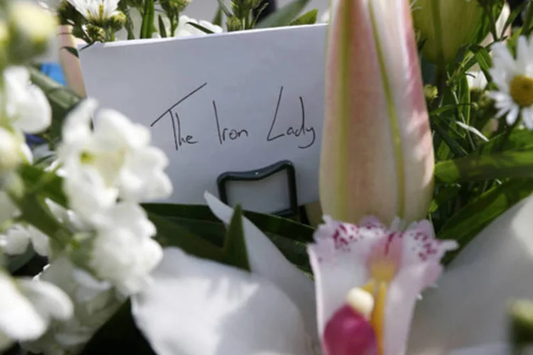 Flores e um bilhete escrito "Dama de Ferro" são vistos do lado de fora da casa da ex-primeira-ministra Margaret Thatcher após o anúncio de sua mortes, em Londres (Suzanne Plunkett/Reuters)
