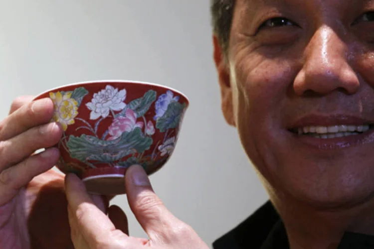 Negociante de Hong Kong William Chak posa com a tijela de porcelana após arrematá-la em leilão da Sotheby's em Hong Kong (Bobby Yip/Reuters)