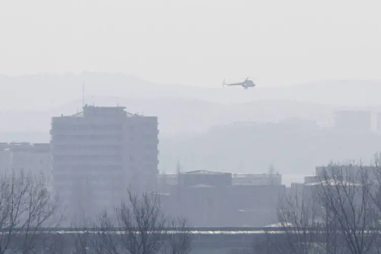 Helicóptero é visto na margem do rio Yalu, próximo da cidade norte-coreana de Sinuiju, em frente a cidade chinesa de Dandong (Jacky Chen/Reuters)