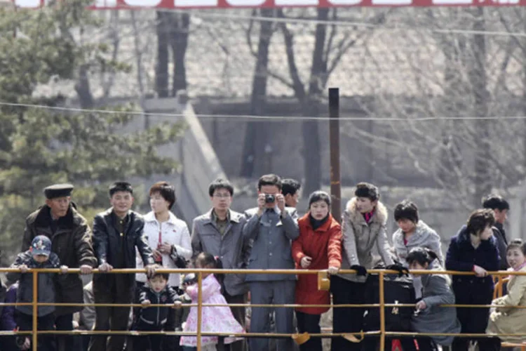 Norte-coreano tira fotos no aniversário de 101 anos do fundador Kim Il-sung, nas margens do rio Yalu, próximo a cidade de Sinuiju (KCNA/Reuters)