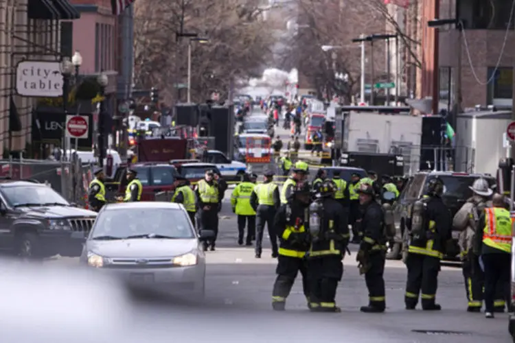 Policiais e bombeiros de Boston examinam o cenário após explosões interromperem a 117a Maratona de Boston, EUA (Dominick Reuter/Reuters)