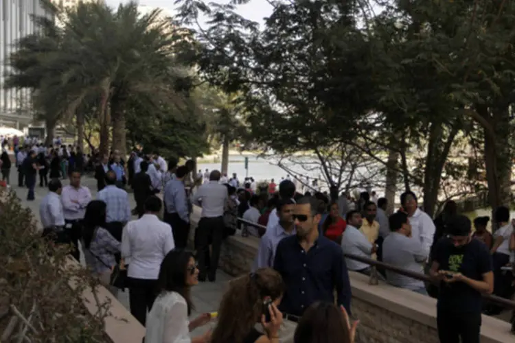 Pessoas esperam após prédios de escritórios serem esvaziados em Dubai por causa de um terremoto (Jumana El Heloueh/Reuters)