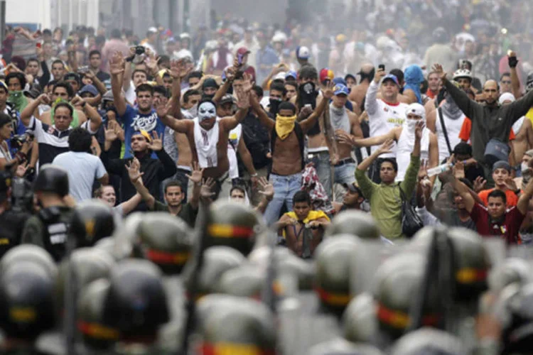 Apoiadores do líder da oposição Henrique Capriles enfrentam policiais em Caracas (Christian Veron/Reuters)