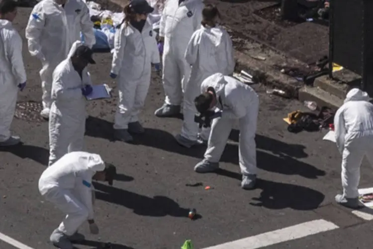 Investigadores examinam o local das explosões na Boylston Street, no dia seguinte a Maratona de Boston (Adrees Latif/Reuters)