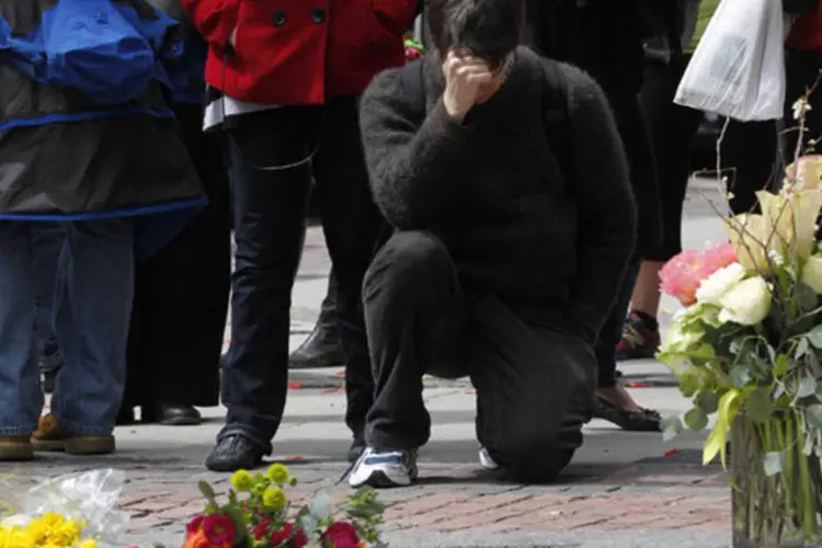 Homem presta homenagens na Boylston Street após a rua ser reaberta para o público pela primeira vez após o atentado com bombas (Jessica Rinaldi/Reuters)