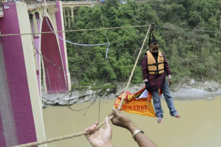 
	O indiano Sailendra Nath Roy &eacute; visto morto ap&oacute;s tentar bater recorde em nova travessia pendurado pelo cabelo em uma corda: ele ficou preso e sofreu um ataque card&iacute;aco
 (Stinger/Reuters)