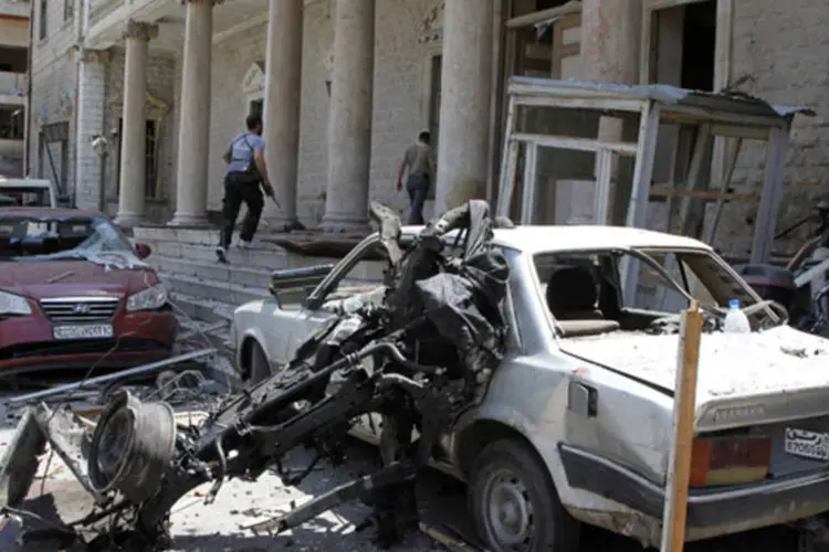Funcionários de segurança transitam em frente ao antigo prédio do Ministério do Interior após uma explosão na praça Marjeh, no centro de Damasco (Khaled al-Hariri/Reuters)