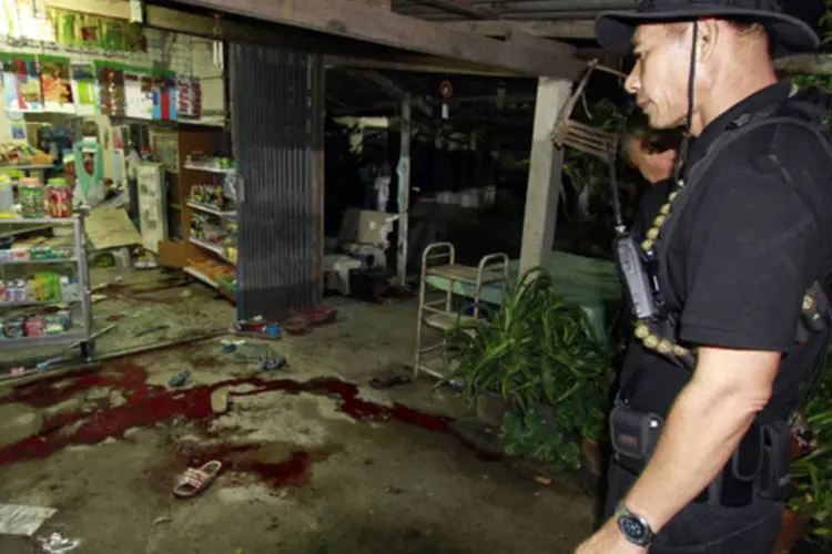 Funcionários de segurança da Tailândia inspecionam loja de conveniência em que seis pessoas foram mortas por militantes islâmicos suspeitos, na província de Pattani (Surapan Boonthanom/Reuters)