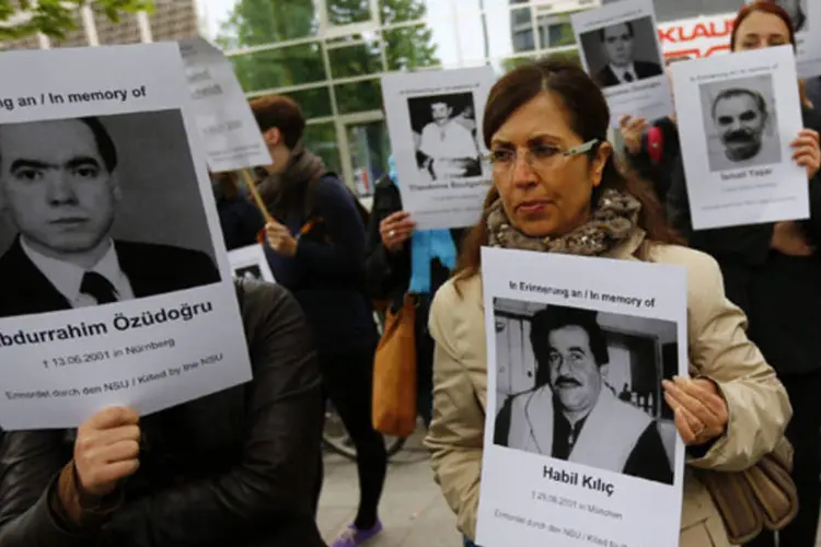 Manifestantes seguram imagens de vítimas do lado de fora do tribunal do julgamento de Beate Zschaepe, membro do grupo neo-nazista Subterrâneo Nacional Socialista (NSU) (Kai Pfaffenbach/Reuters)