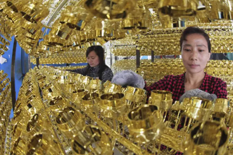 Funcionário trabalhando em uma linha de tampas para garragas de vinho em uma fábrica em Ganyu, na província de Jiangsu (China Daily/Reuters)
