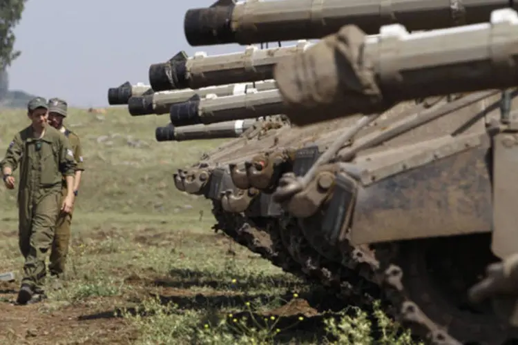 Soldados israelenses caminham perto de tanques na região da linha de cessar-fogo entre Israel e Síria, na região ocupada das Colinas do Golã (Baz Ratner/Reuters)