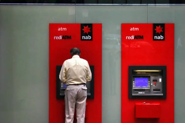Homem sacando dinheiro de um caixa-eletrônico do National Australia Bank no centro de Sydeny, Austrália (David Gray/Retures)