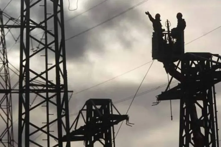 Trabalhadores removem partes de um poste de energia para reconstruir a linha de transmissão na cidade de Meckenheim, na Alemanha (Ina Fassbender/Reuters)