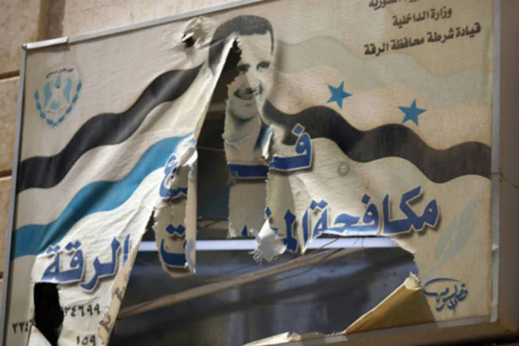 
	Foto rasgada do atual presidente da S&iacute;ria Bashar al-Assad &eacute; visto em um pr&eacute;dio governamental na prov&iacute;ncia de Ragga, no leste do pa&iacute;s
 (Hamid Khatib/Reuters)