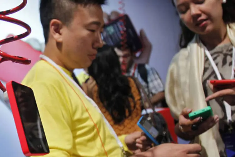 
	Visitantes olham ao novo smartphone da linha Asha da Nokia, de US$ 99, depois de seu lan&ccedil;amento em Nova D&eacute;lhi, na &Iacute;ndia
 (Anindito Mukherjee/Reuters)