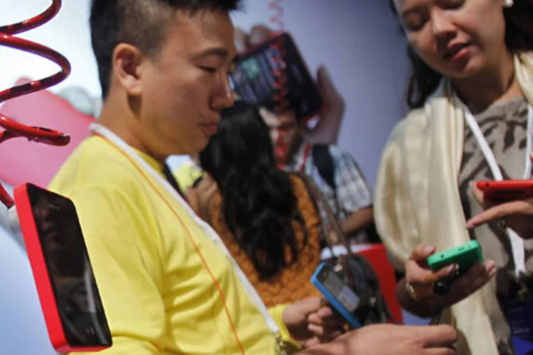 
	Visitantes olham ao novo smartphone da linha Asha da Nokia, de US$ 99, depois de seu lan&ccedil;amento em Nova D&eacute;lhi, na &Iacute;ndia
 (Anindito Mukherjee/Reuters)