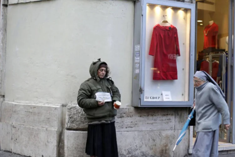 
	Freira caminha enquanto mulher pede esmola em Roma: n&uacute;mero de pessoas vivendo em fam&iacute;lias consideradas seriamente carentes chegou a 8,6 milh&otilde;es, ou 14% da popula&ccedil;&atilde;o
 (Max Rossi/Reuters)