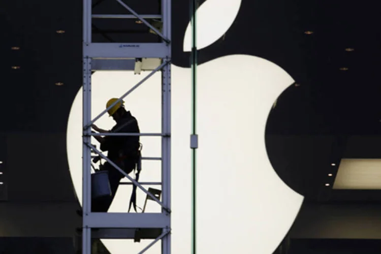 
	Trabalhador &eacute; visto em frente ao s&iacute;mbolo da Apple: aumento dos pre&ccedil;os s&atilde;o raros no Jap&atilde;o, que sofreu 15 anos de defla&ccedil;&atilde;o de baixo n&iacute;vel
 (Bobby Yip/Reuters)