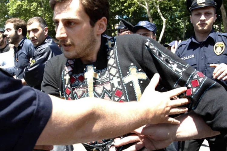 
	Policial tenta parar crist&atilde;o ortodoxo durante conflitos na parada gay da Ge&oacute;rgia: a Igreja Ortodoxa Georgiana, com grande influ&ecirc;ncia no pa&iacute;s, tinha feito um apelo para se proibir o evento
 (David Mdzinarishvili/Reuters)