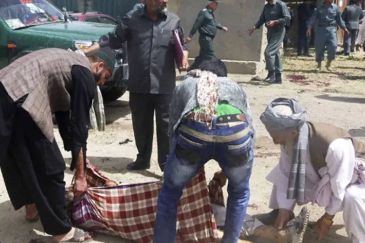 
	Pessoas carregando corpo de uma das v&iacute;timas de um ataque suicida: alvo era Mohammad Rasoul Mohseni, chefe de gabinete do conselho provincial
 (Reuters)