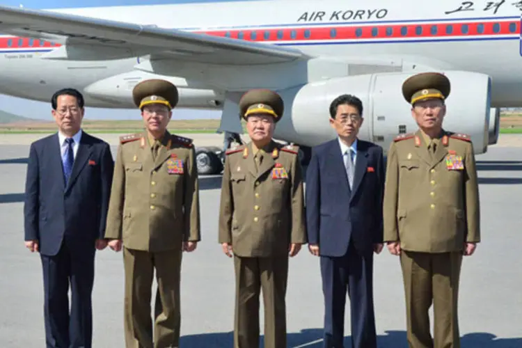 Choe Ryong-hae (centro) no aeroporto de Pyongyang com sua delegação antes de viajar para a China como enviado especial do líder Kim Jong-un (KCNA/Reuters)