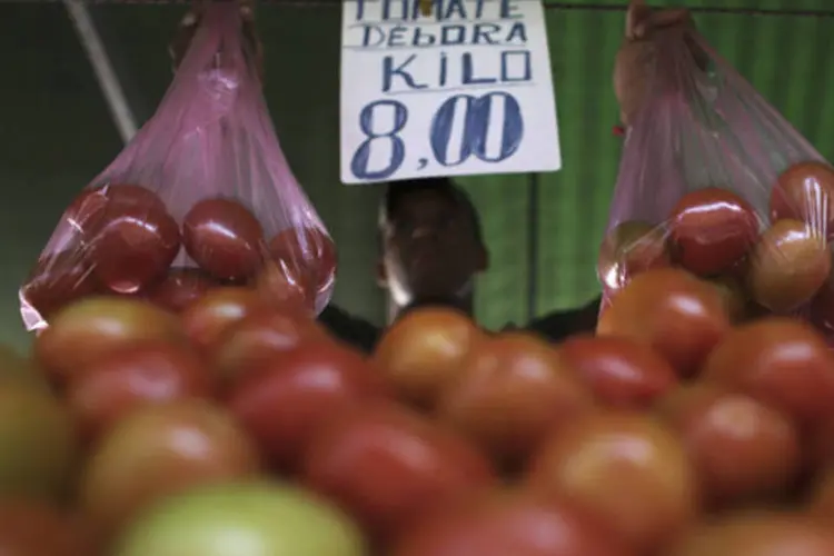 
	Vendedor segura sacola de tomates em Feira Livre no bairro da Mooca: em maio, a desacelera&ccedil;&atilde;o dos pre&ccedil;os dos alimentos ajudou o IPCA a registrar a menor alta em quase um ano
 (Nacho Doce/Reuters)