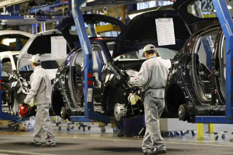 Funcionários trabalham na linha de montagem de carros da Peugeot Citroen na fábrica de Poissy, perto de Paris (Gonzalo Fuentes/Reuters)