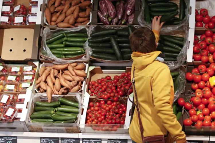 
	Mulher olha legumes em mercado: a alta nos pre&ccedil;os na categoria Alimenta&ccedil;&atilde;o desacelerou para 1,56% na terceira quadrissemana de abril
 (Fabrizio Bensch/Reuters)