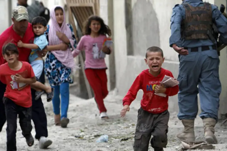 Crianças correm após uma explosão em Cabul, no Afeganistão: chefe da polícia de Cabul disse que quatro agressores invadiram o complexo da ONU (Omar Sobhani/Reuters)