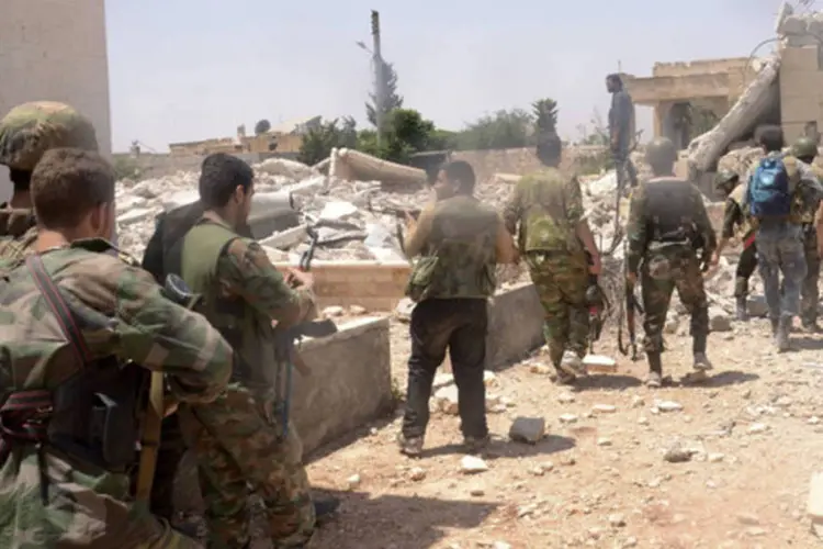 Forças leais ao presidente sírio Bashar al-Assad carregam suas armas durante uma operação em Aleppo, na Síria (George Ourfalian/Reuters)