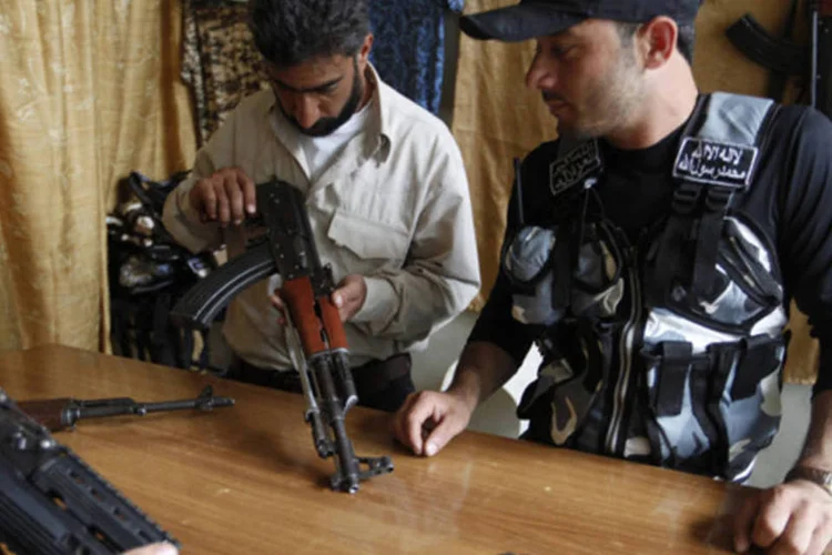 Membro do Exército Sírio Livre olha armas em loja no bairro de al-Myassar, em Aleppo (Hamid Khatib/Reuters)