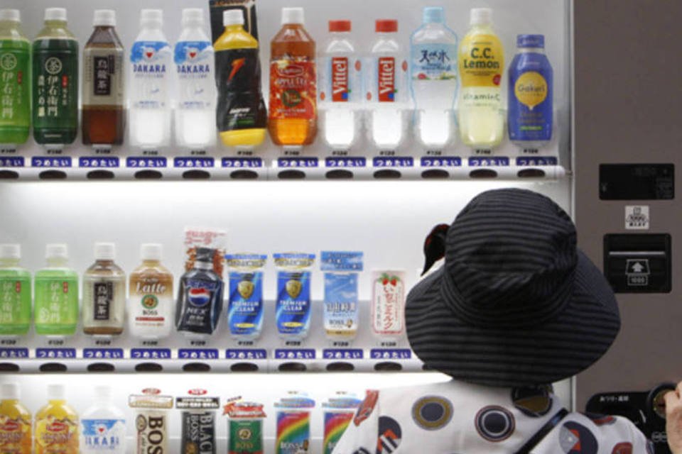 Mulher compra uma bebida da Suntory em uma máquina de vendas da companhia em Tóquio, no Japão (Yuriko Nakao/Reuters)