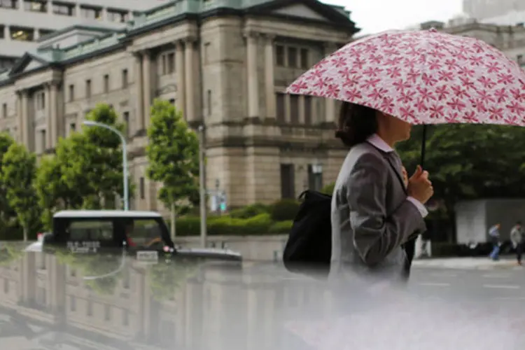 Mulher passa pela sede do Banco do Japão (BoJ): autoridade monetária não adotou medidas nesta terça-feira, argumentando que os mercados de títulos se estabilizaram (Yuya Shino/Reuters)