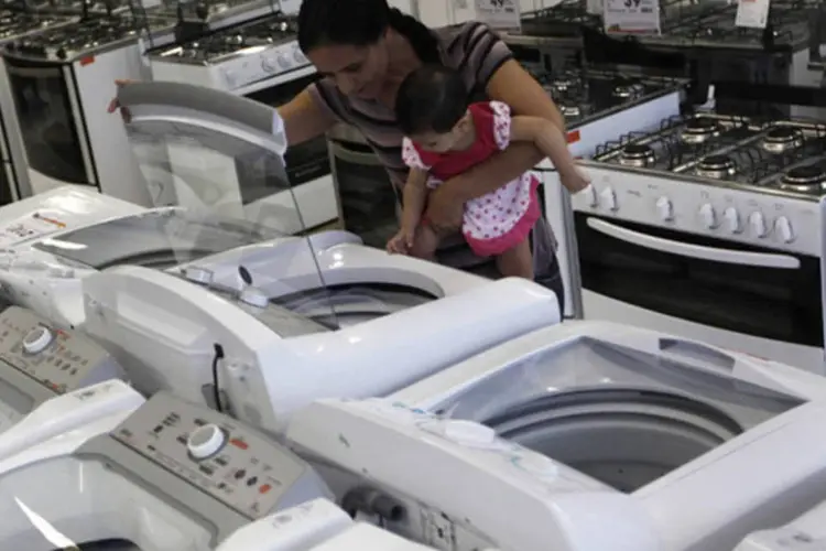 
	Mulher com crian&ccedil;a examina m&aacute;quina de lavar em loja: Procel trabalha em parceria com Inmetro e com associa&ccedil;&otilde;es de fabricantes, uma vez que a ades&atilde;o ao Selo Procel &eacute; volunt&aacute;ria
 (Nacho Doce/Reuters)