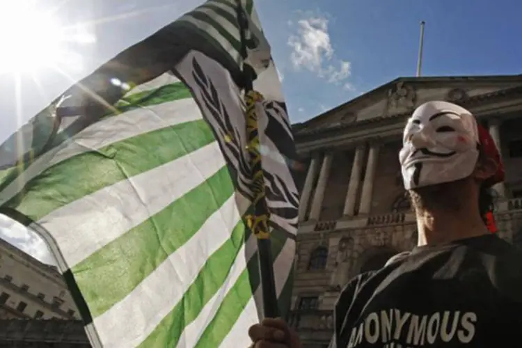 Manifestante com máscara de Guy Fawkes, símbolo do grupo Anonymous UK, protesta em frente ao Banco da Inglaterra, em Londres (Luke MacGregor/Reuters)