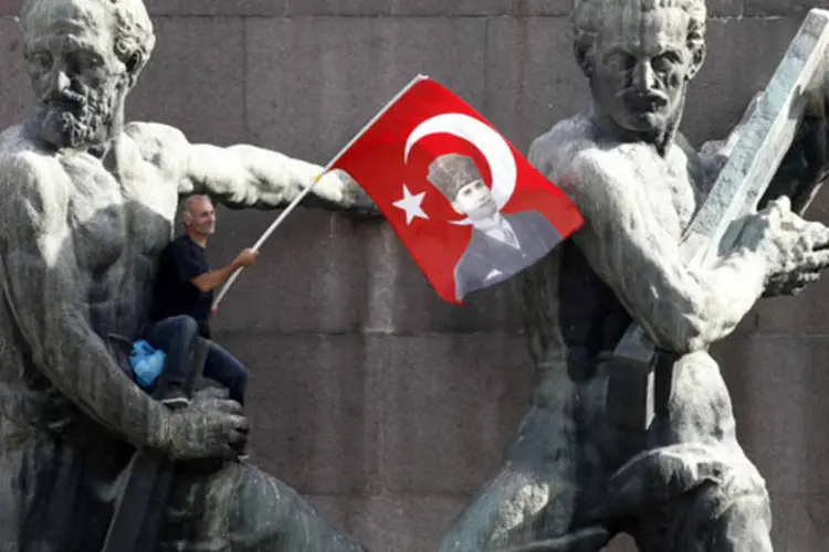 
	Manifestante com a bandeira nacional turca:&nbsp;no domingo, Erdogan, que presidir&aacute; seu conselho de ministros nesta segunda-feira, endureceu o tom diante das manifesta&ccedil;&otilde;es.
 (Umit Bektas/Reuters)