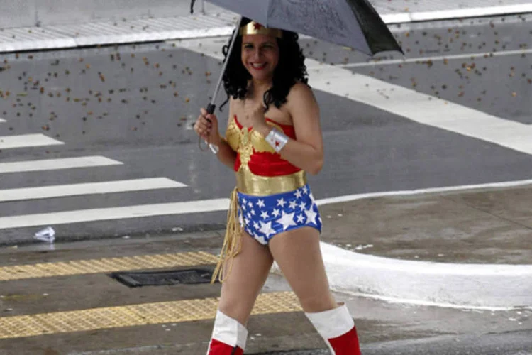 Travesti vestida de Mulher Maravilha atravessa a rua sob a chuva de São Paulo durante a 17ª Parada Gay (Paulo Whitaker/Reuters)