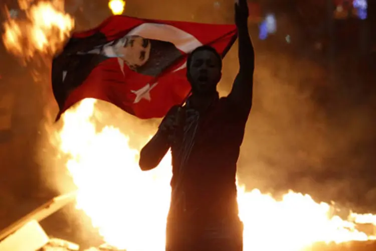 Manifestante anti-governo segura a bandeira da Turquia com o retrato de Mustafa Kemal Ataturk, fundador da Turquia moderna, durante uma manifestação em Ancara (Umit Bektas/Reuters)