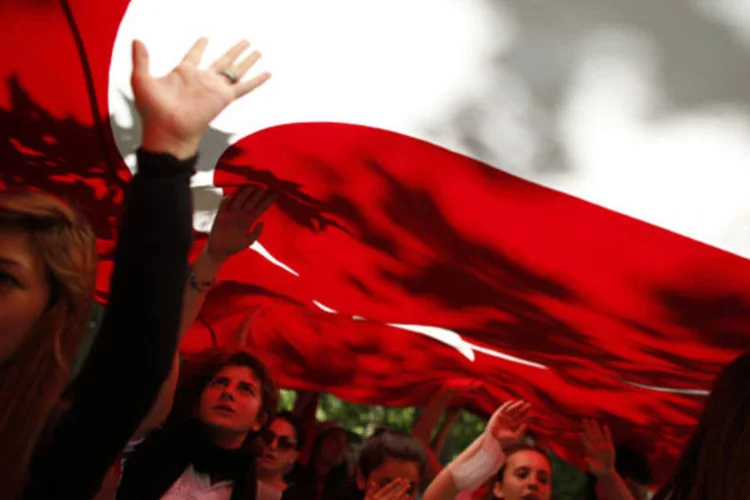 
	Manifestantes carregam bandeir&atilde;o turco durante passeata contra o primeiro-ministro, no centro de Ancara: na capital, pela primeira vez, incidentes e confrontos n&atilde;o foram registrados
 (Umit Bektas/Reuters)