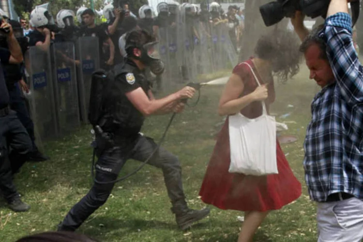 
	&ldquo;A mulher de vermelho&rdquo; tenta desviar de jato de g&aacute;s lacrimog&ecirc;neo, na Turquia, em junho de 2013: acusa&ccedil;&atilde;o est&aacute; embasada em dados que calculam 7.822 feridos e quatro mortos nos protestos
 (Osman Orsal / Reuters)