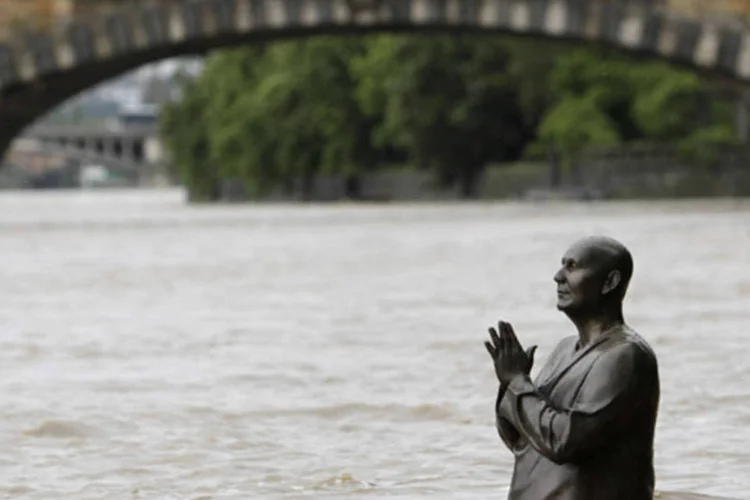 Estátua do líder da harmonia mundial Sri Chinmoy parcialmente submersa pela água do rio Vltava, que transbordou em Praga (David W Cerny/Reuters)