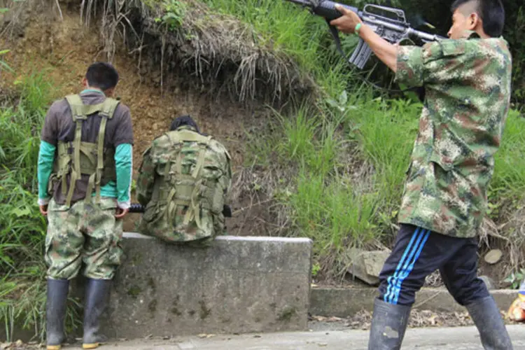 Um membro das Forças Revolucionárias da Colômbia atira próximo das montanhas de Caldono, na província de Cuaca (Jaime Saldarriaga/Reuters)
