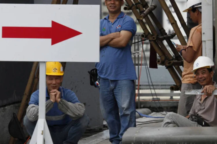 Trabalhadores da construção descansam no telhado de uma obra no antigo aeroporto de Kai Tak, em Hong Kong (Bobby Yip/Reuters)