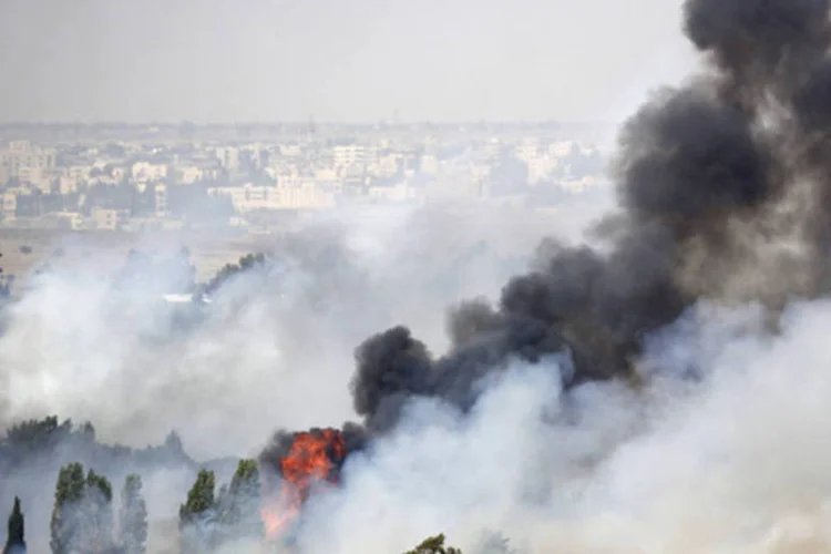 Fogo visto junto à passagem de fronteira Quneitra, em foto tirada a partir das colinas de Golã, próximo à linha de cessar-fogo entre Israel e Síria (Ammar Awad/Reuters)
