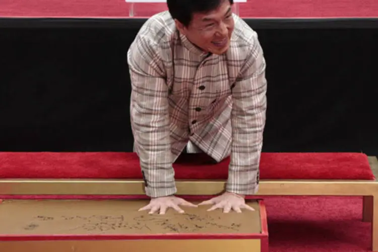 Ator Jackie Chan deixa as marcas de suas mãos no cimento molhado durante cerimônia no Teatro Chinês, em Hollywood (Jonathan Alcorn/Reuters)