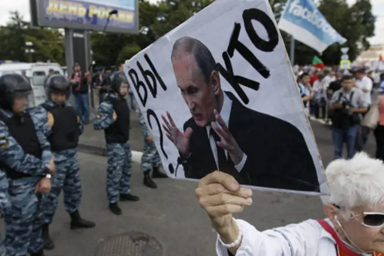 
	Manifestantes seguram retratos de ativistas presos e balan&ccedil;am bandeiras durante protesto em Moscou: &quot;Putin vergonha da R&uacute;ssia&quot;, afirmavam alguns cartazes
 (Sergei Karpukhin/Reuters)