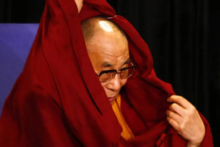 Líder espiritual do Tibet, Dalai Lama, arruma seu roupão durante conferência de imprensa em Sidney, na Austrália (David Gray/Retures)