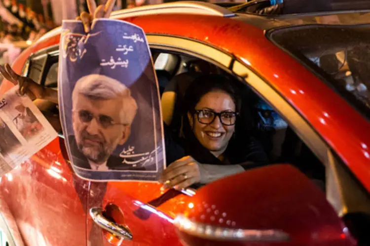 Apoiador dos candidatos presidenciais Hassan Rohani (E) e Saeed Jalili (D) em um carro nas ruas de Teerã, no Irã (Fars News/Sina Shiri/Reuters)