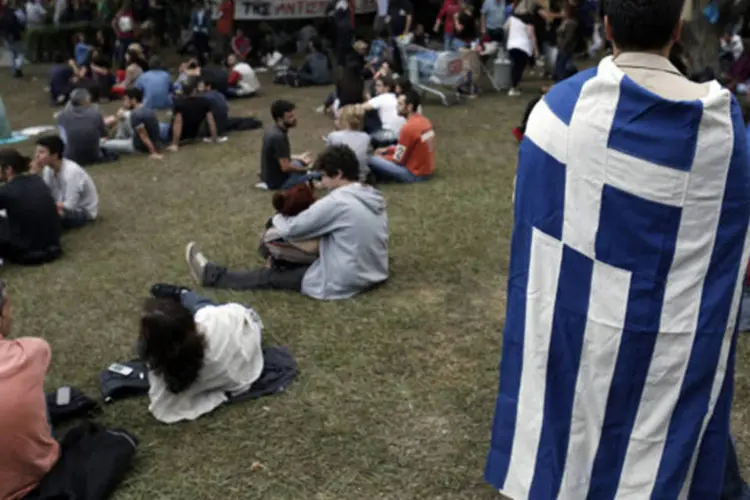 
	Manifestante com a bandeira grega: analista-chefe de d&iacute;vida soberana da S&amp;P disse que n&atilde;o h&aacute; nenhuma grande amea&ccedil;a com as medidas dos Estados Unidos
 (John Kolesidis/Reuters)