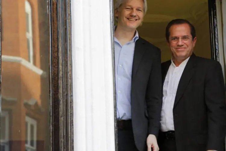 Fundador do WikiLeaks Julian Assange acena da janela com o chanceler do Equador, Ricardo Patiño, na embaixada do país, em Londres (Chris Helgren/Reuters)